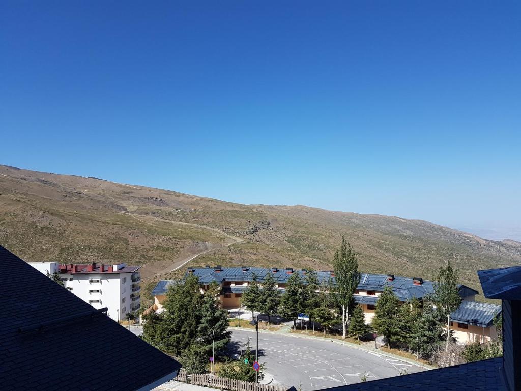 Blick auf eine Stadt mit einem Berg im Hintergrund in der Unterkunft MARBELLA FRENTE AL TELESILLA in Sierra Nevada