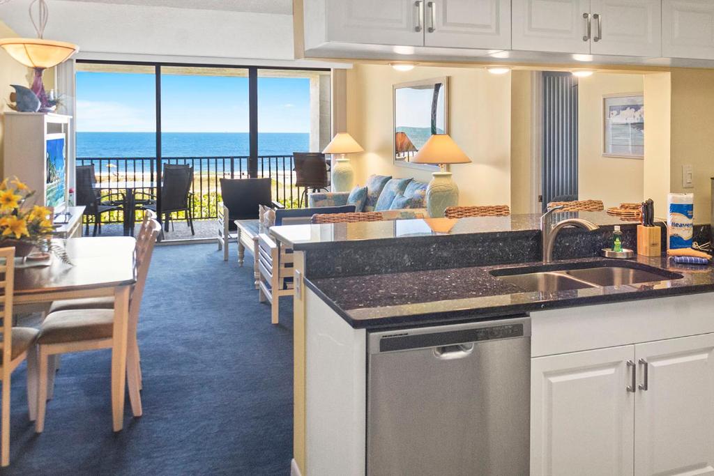a kitchen and living room with a view of the ocean at Cape Winds Resort in Cape Canaveral