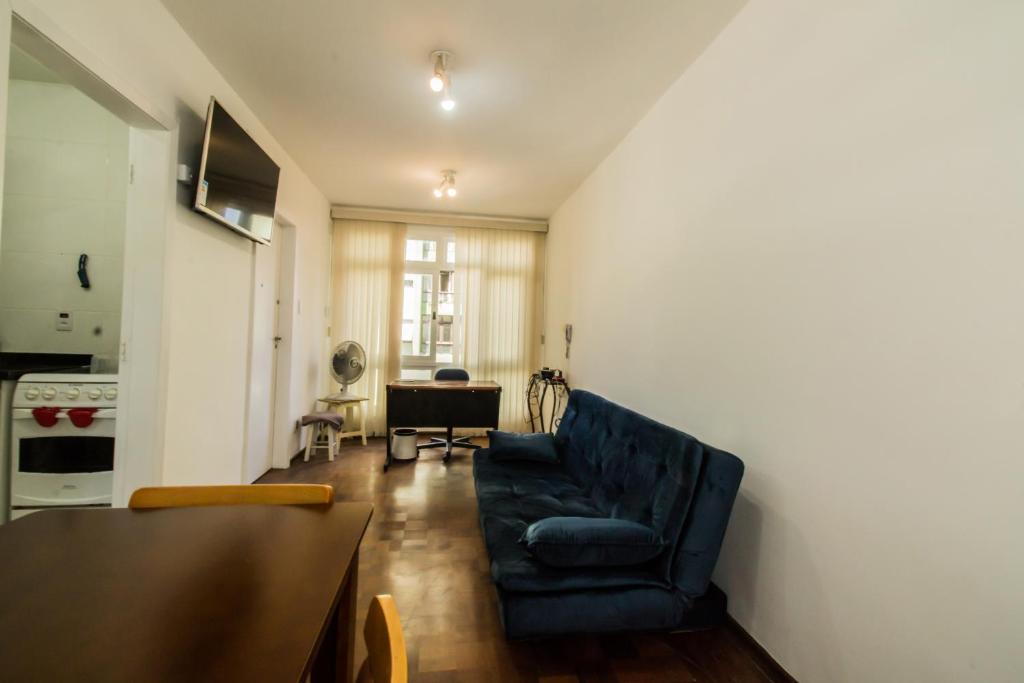 a living room with a blue chair and a table at Apartamento aconchegante com estacionamento na 25 de março in Sao Paulo