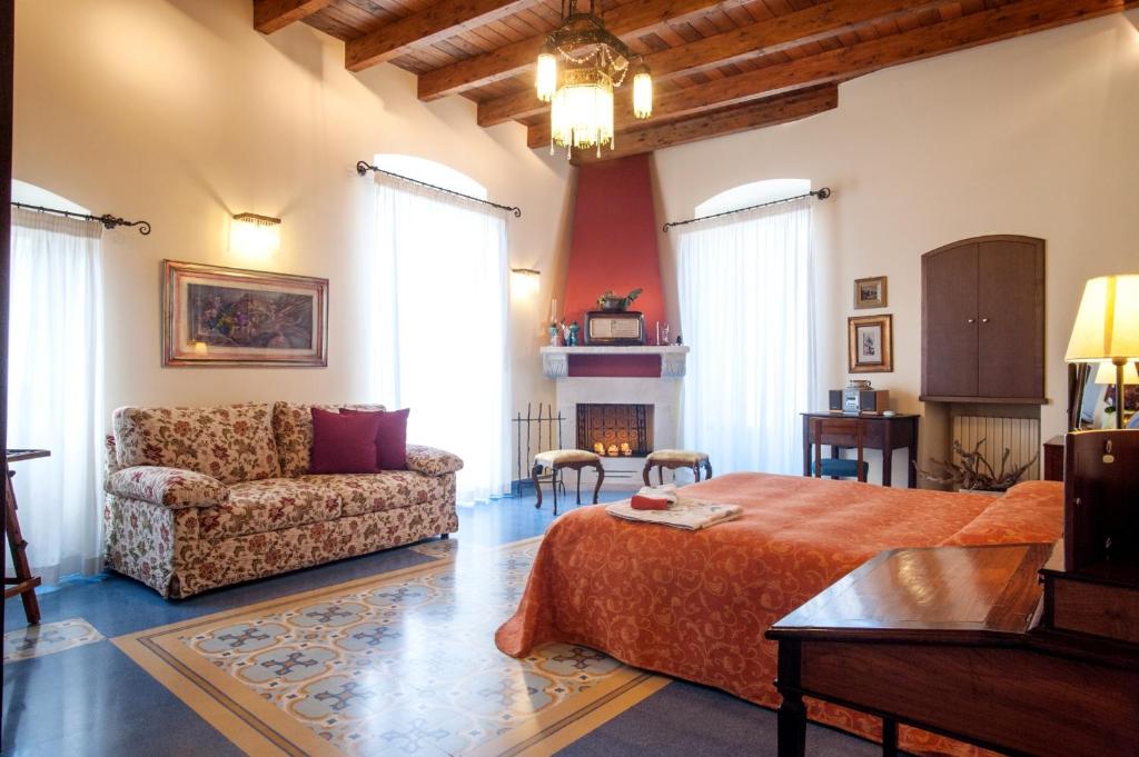 a bedroom with a bed and a couch and a fireplace at VinsLounge Suite in Barletta