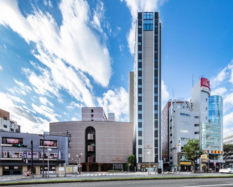 
a tall building with a clock on the side of it at Hotel Emisia Tokyo Tachikawa in Tachikawa
