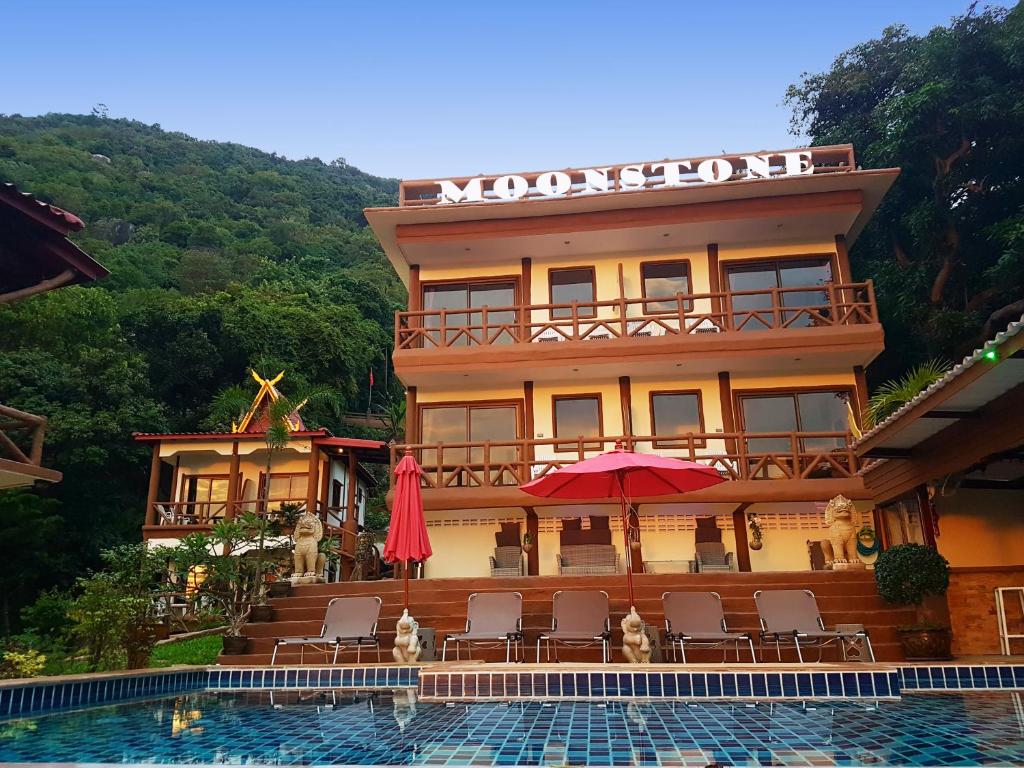 a hotel with a swimming pool in front of a building at Moonstone Studio in Haad Rin