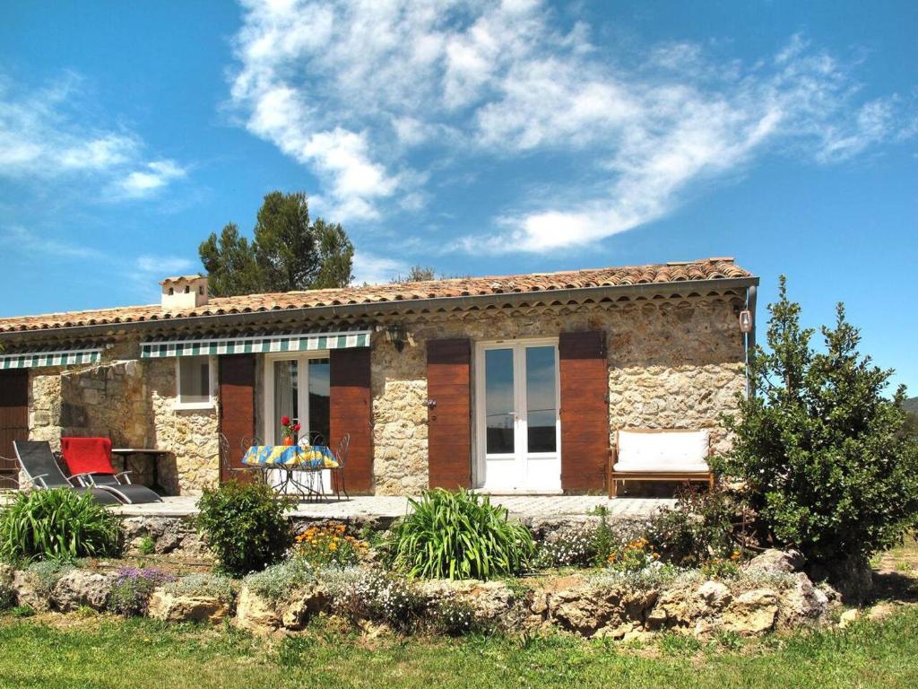 a small stone house with a bench in front of it at Le Logis, charmant gîte provençal in Ampus