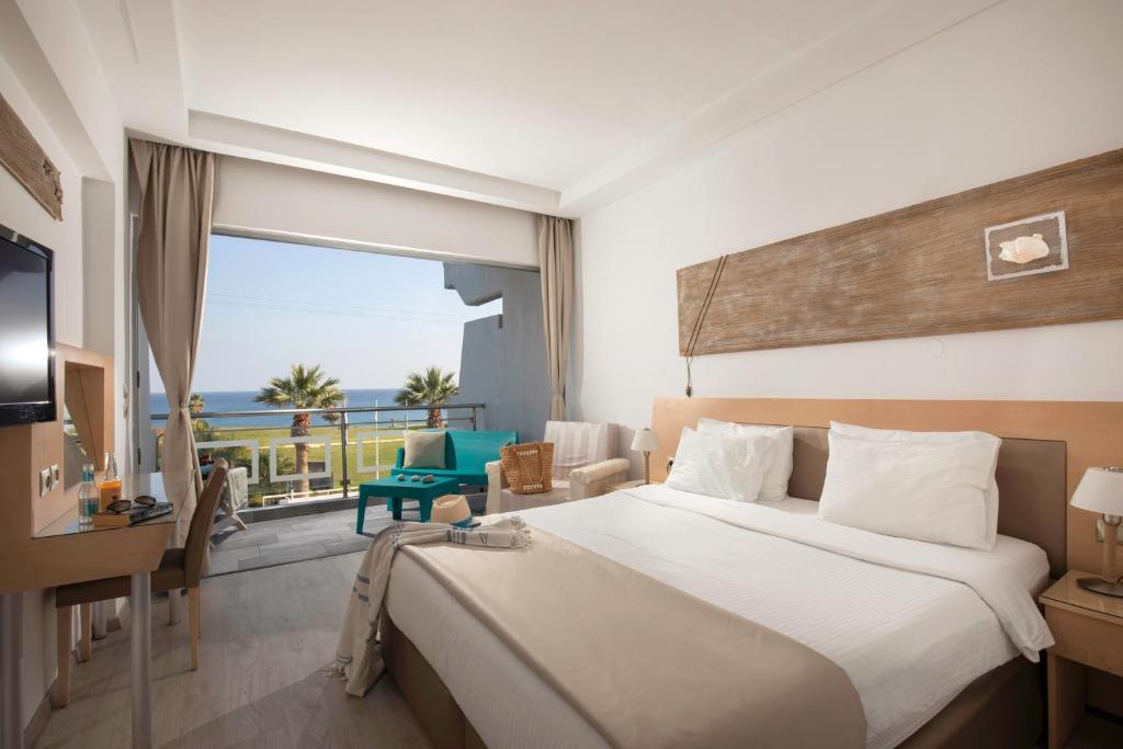 a hotel room with two beds and a television at Kolymbia Bay Art - Adults Only in Kolymbia