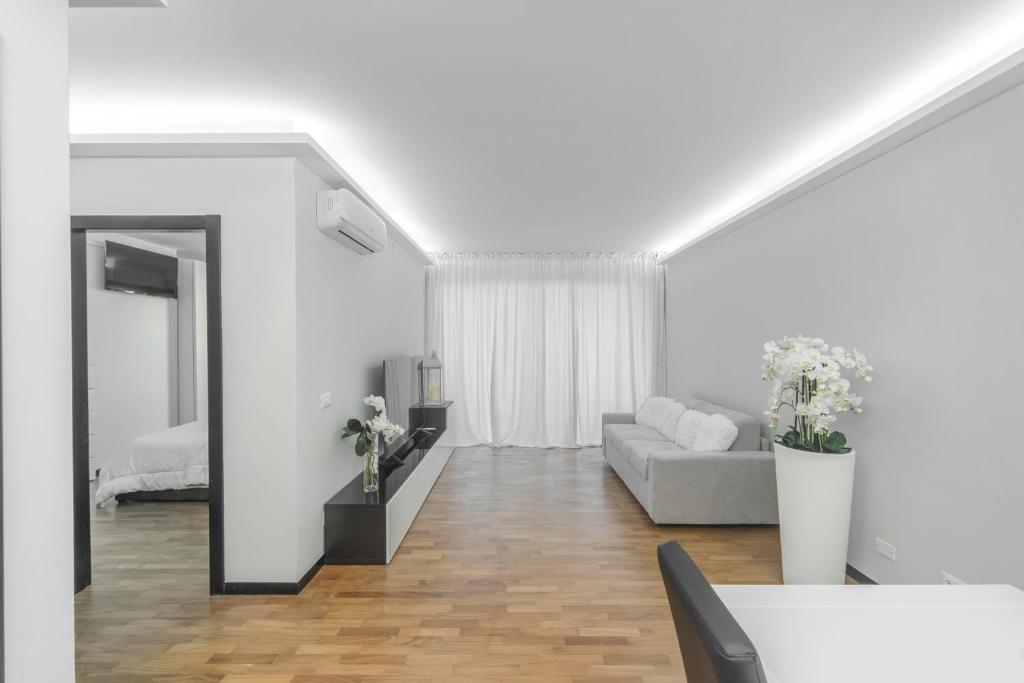 un soggiorno bianco con divano e specchio di Guest House Foligno Porta Romana a Foligno