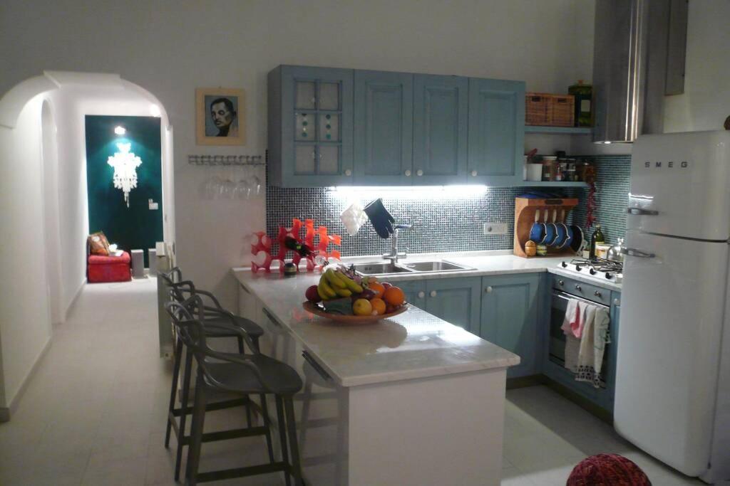 a kitchen with blue cabinets and a bowl of fruit on a counter at Boutique by the Sea in Positano