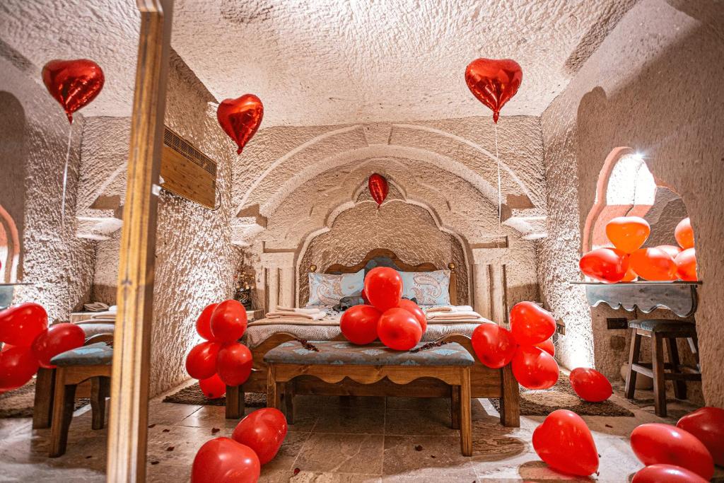 アヴァノスにあるSeval White House Kapadokyaの赤風船が床に敷かれた部屋、ベッド1台が備わる部屋