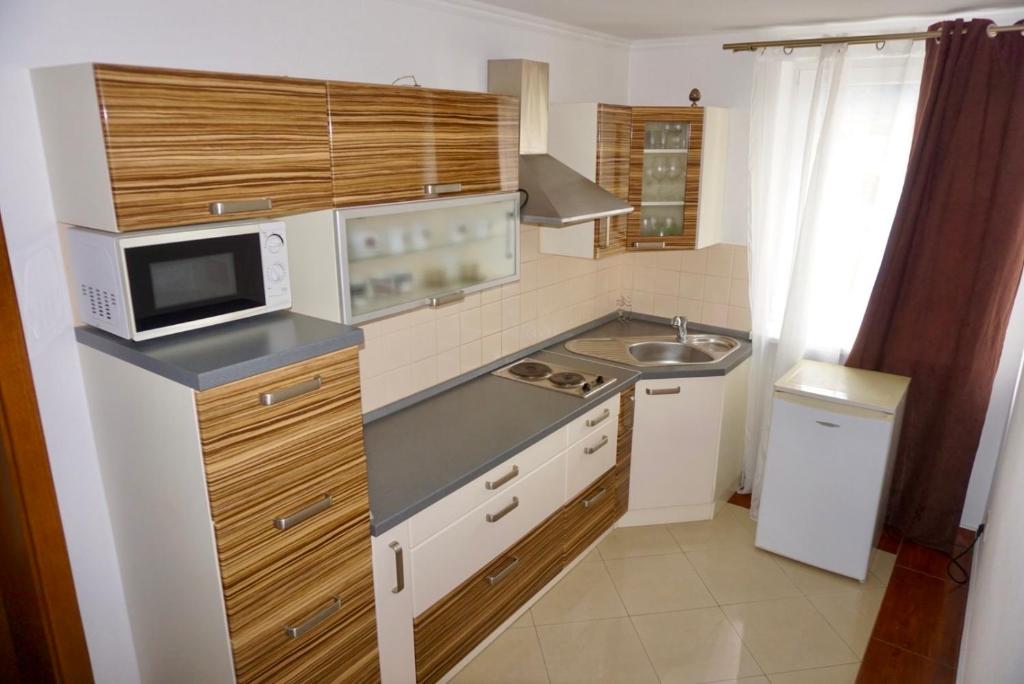 a small kitchen with a sink and a microwave at Penzion Vegas in Partizánske