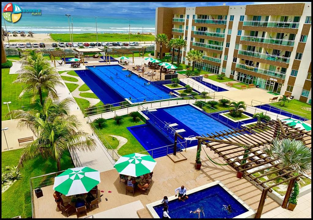 - une vue aérienne sur un complexe avec 2 piscines et des parasols dans l'établissement VG FUN 131 Praia do Futuro, à Fortaleza