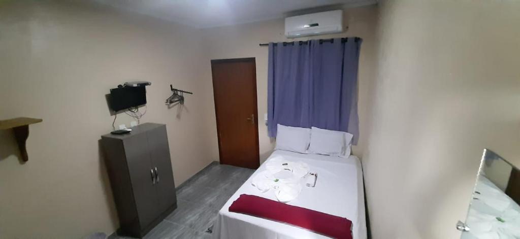 a small room with a bed and a television at Pousada Centaurus in Alto Paraíso de Goiás