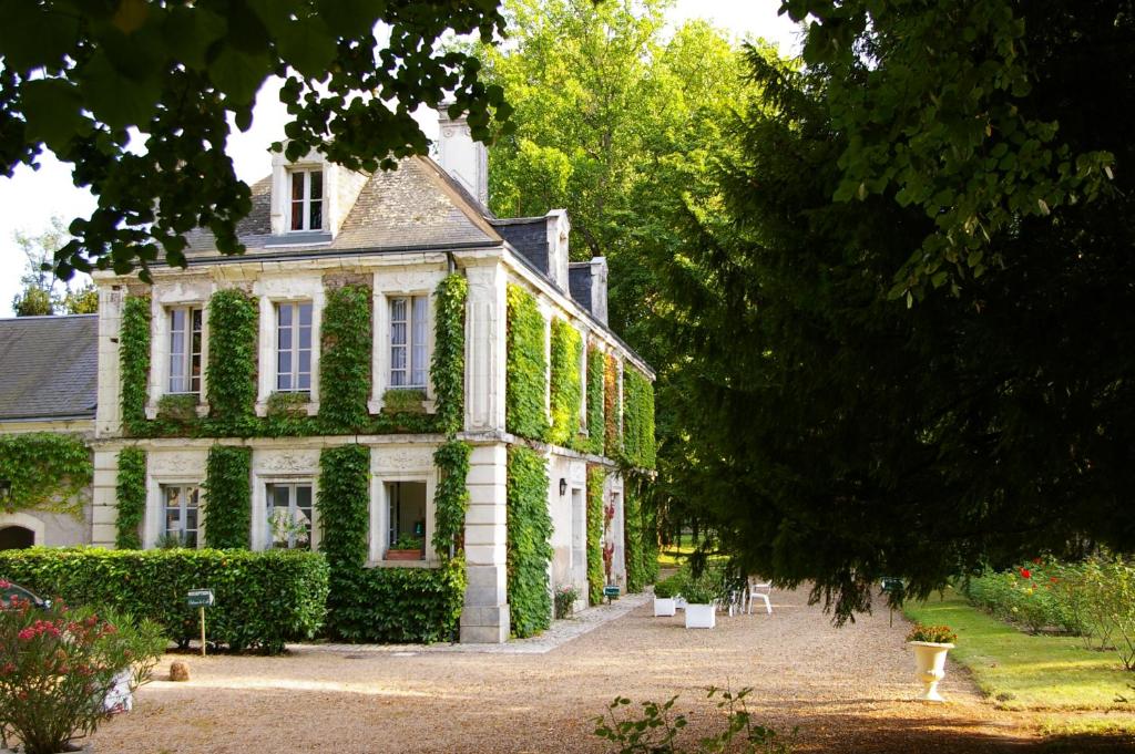 una casa con hiedra creciendo a su lado en Chambres d'hôtes du domaine de l'Isle en Civray-de-Touraine