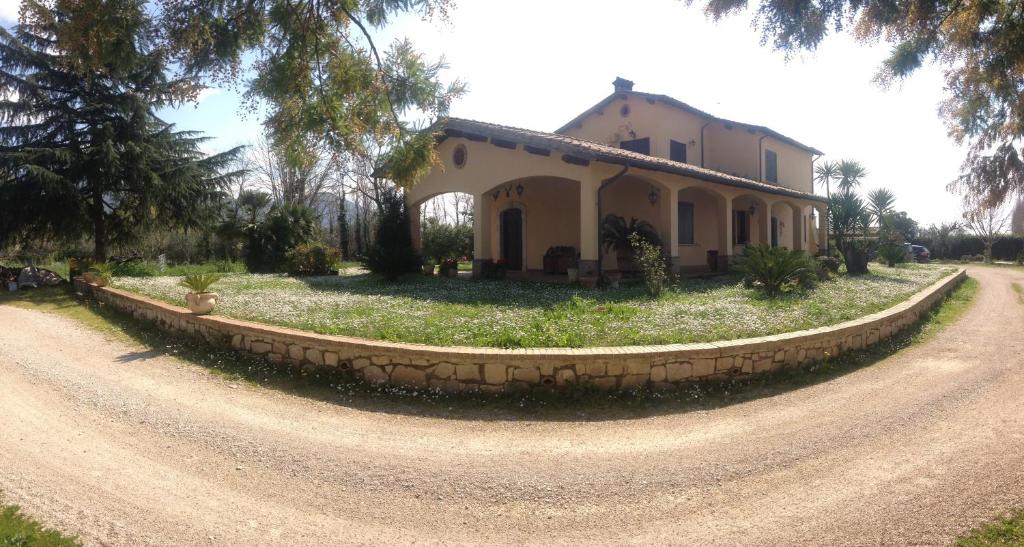 a house on the side of a dirt road at Casal Dei Papi in Sermoneta