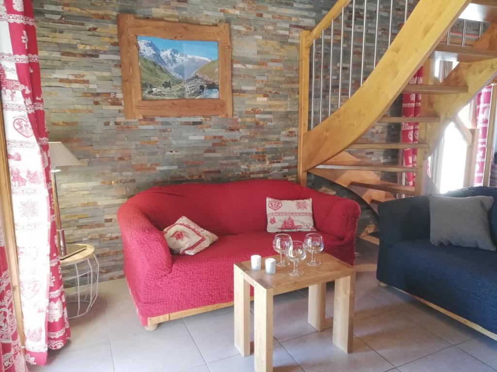 a living room with a red couch and a table at crocus in Saint-Martin-de-Belleville