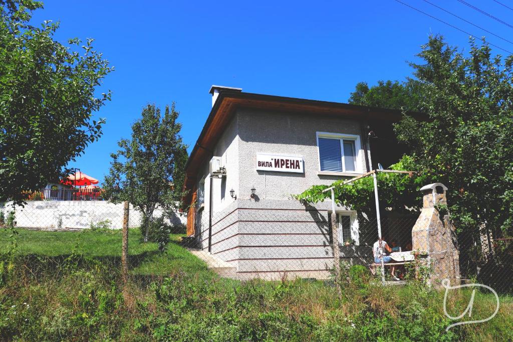 a man sitting on a bench outside of a house at вила Ирена in Radevtsi