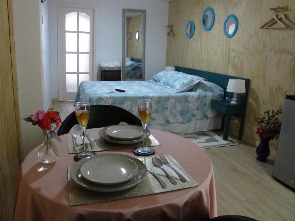 Zimmer mit einem Tisch mit Tellern und Weingläsern in der Unterkunft Cabañas Lemupewen Chillán 3 y 4 in Chillán