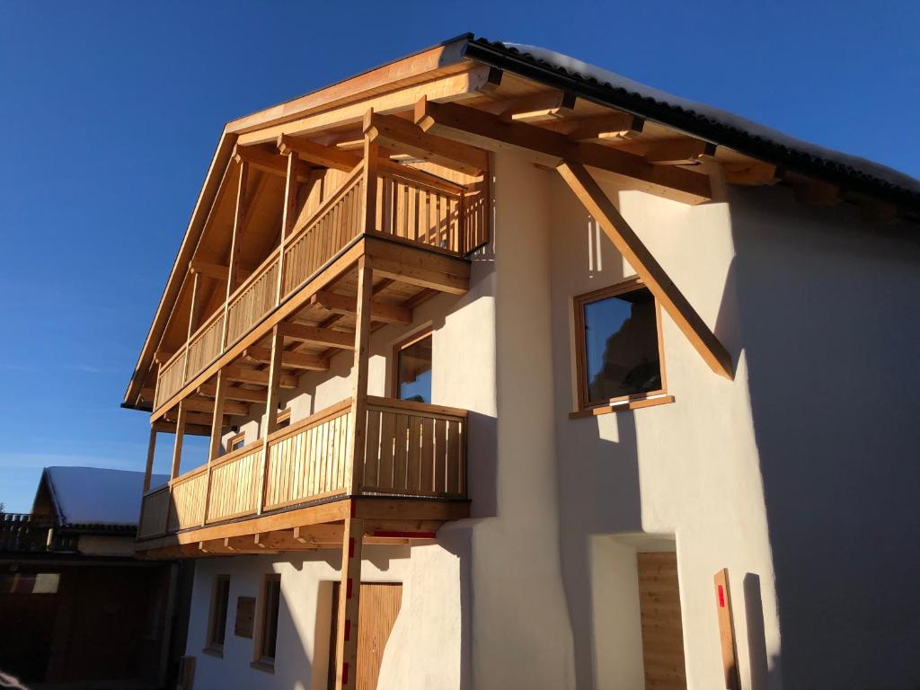 a building with a deck on the side of it at Latemar Fiemme Apartments in Tesero