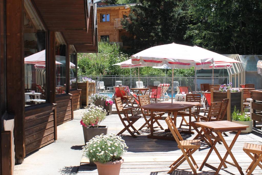a patio with tables and chairs and umbrellas at Hotel Adret in Les Deux Alpes