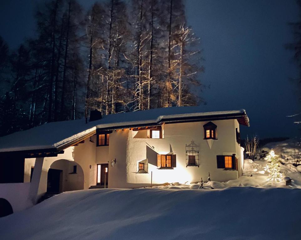 ダボスにあるChalet Chesa Surlej, Davosの雪中のクリスマスツリーのある家