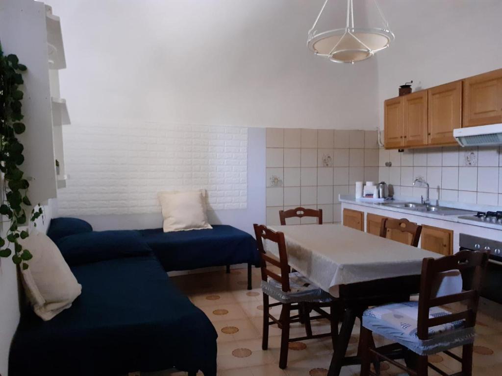 a kitchen with a blue couch and a table and chairs at Emidio House in Termini
