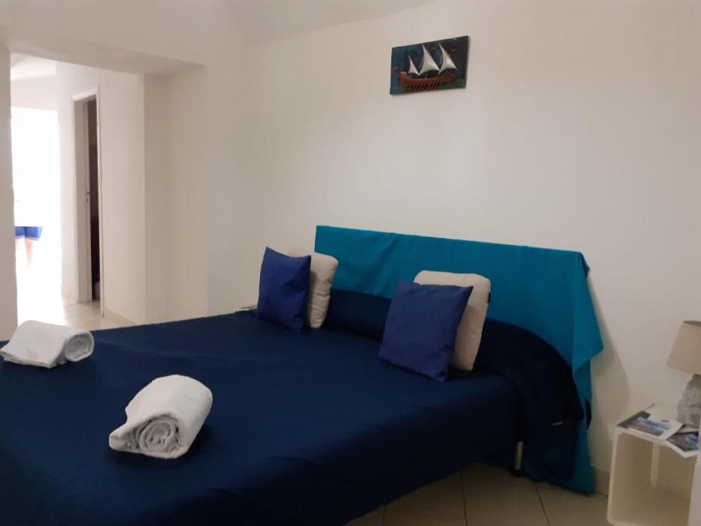 a blue bed with blue sheets and pillows at Emidio House in Termini