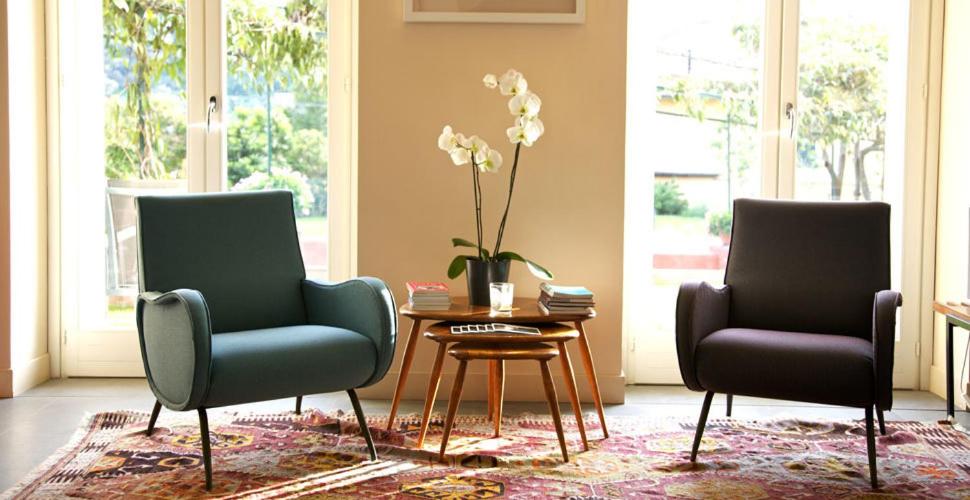 a living room with two chairs and a table with a vase at Villa Rosmarino in Camogli