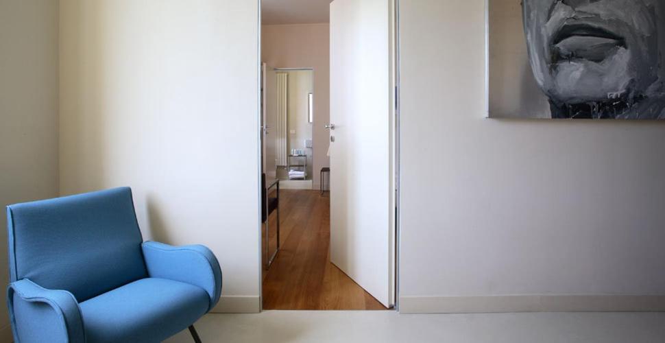 a blue chair in a room with a mirror at Villa Rosmarino in Camogli