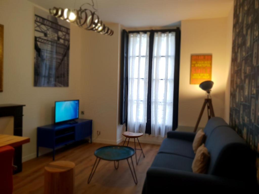 a living room with a blue couch and a tv at L'Appart l'Escapade Coeur de Nantes in Nantes