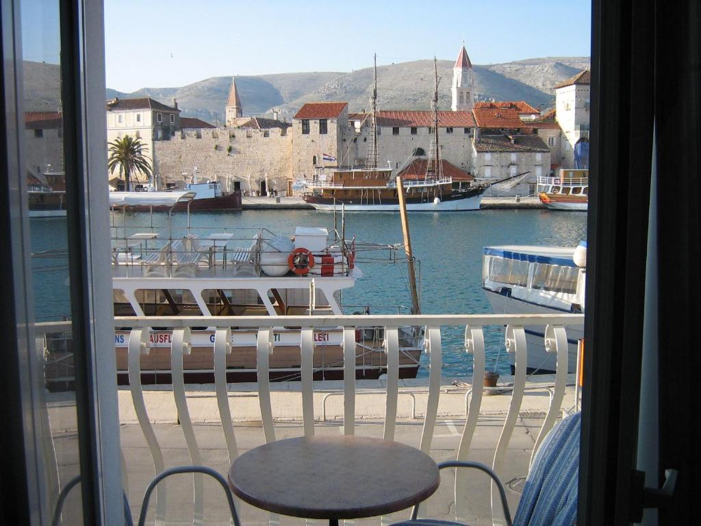 a balcony with a table and a boat in a harbor at Villa Tudor in Trogir