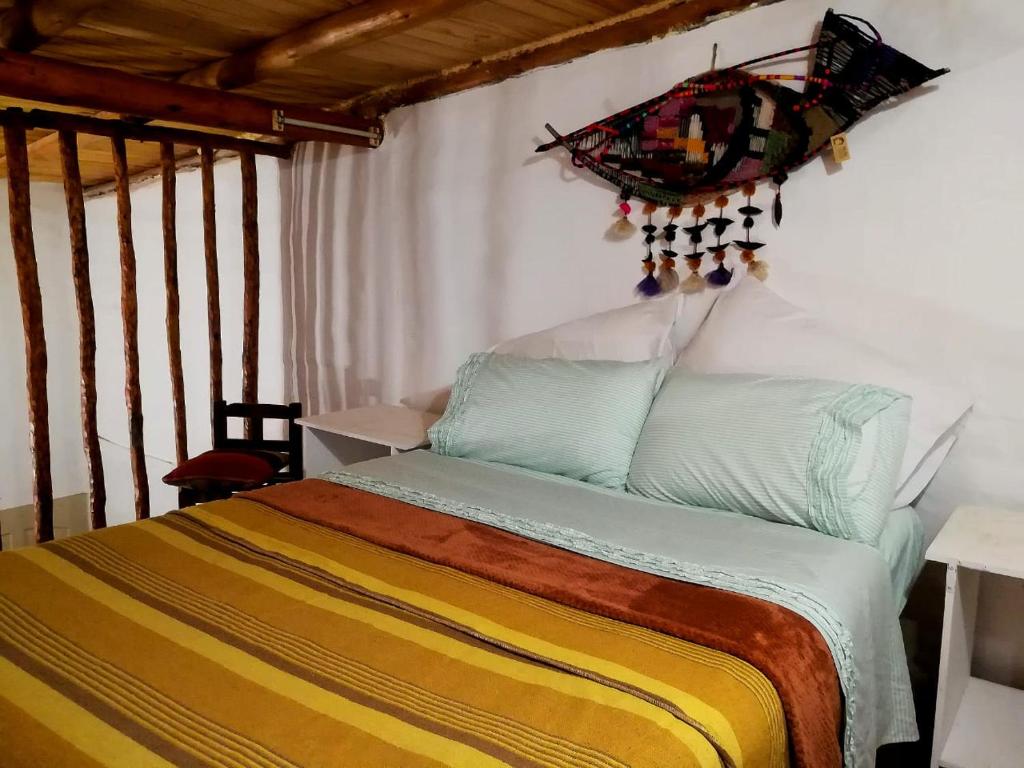 a bedroom with a bed with a chandelier on the wall at Cabañas Paqa Paqa in Maimará