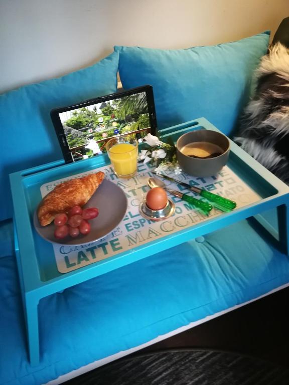 a table with a tray of food on a couch at Study du pêcheur in Trouville-sur-Mer