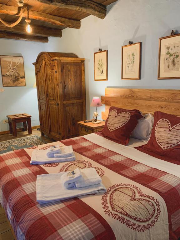 sypialnia z dwoma łóżkami i ręcznikami na nich w obiekcie Locanda Allevè Hotel Ristorante w mieście Pragelato