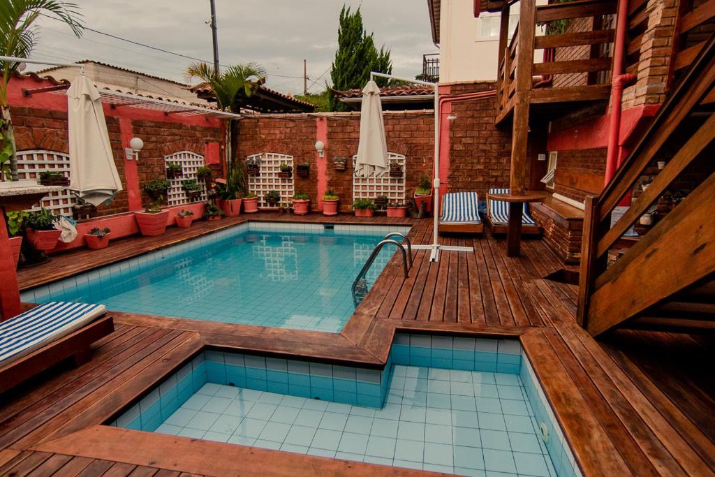 uma piscina com um deque de madeira em Pousada Brilho da Serra em Tiradentes