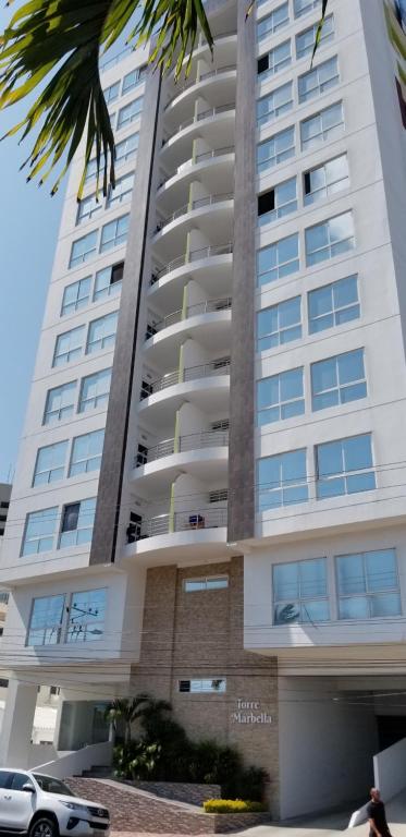 un edificio alto con un coche aparcado delante de él en Kattyapartament 1103vista al mar, en Salinas