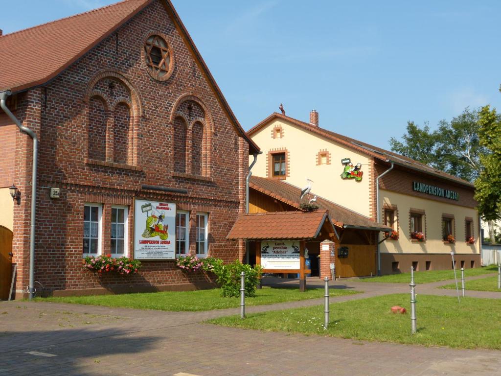a large brick building with a sign in front of it at Landpension Adebar in Linum