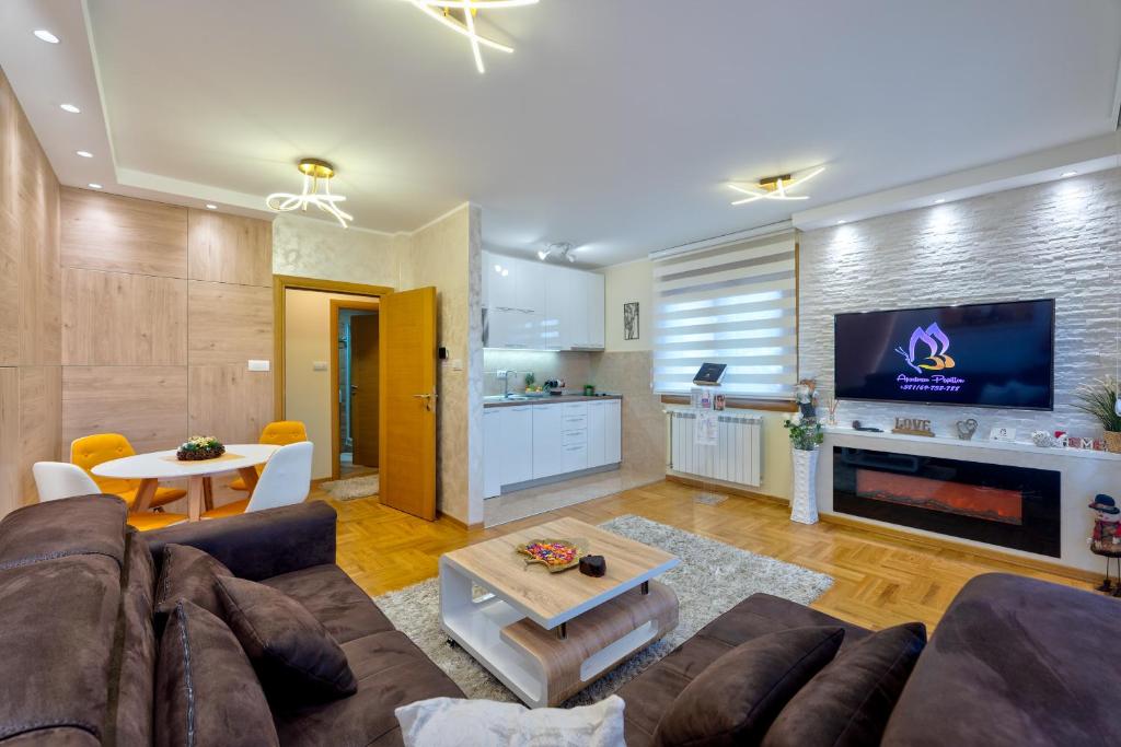 ein Wohnzimmer mit einem Sofa und einem TV in der Unterkunft Apartment Papillon 3 in Zlatibor