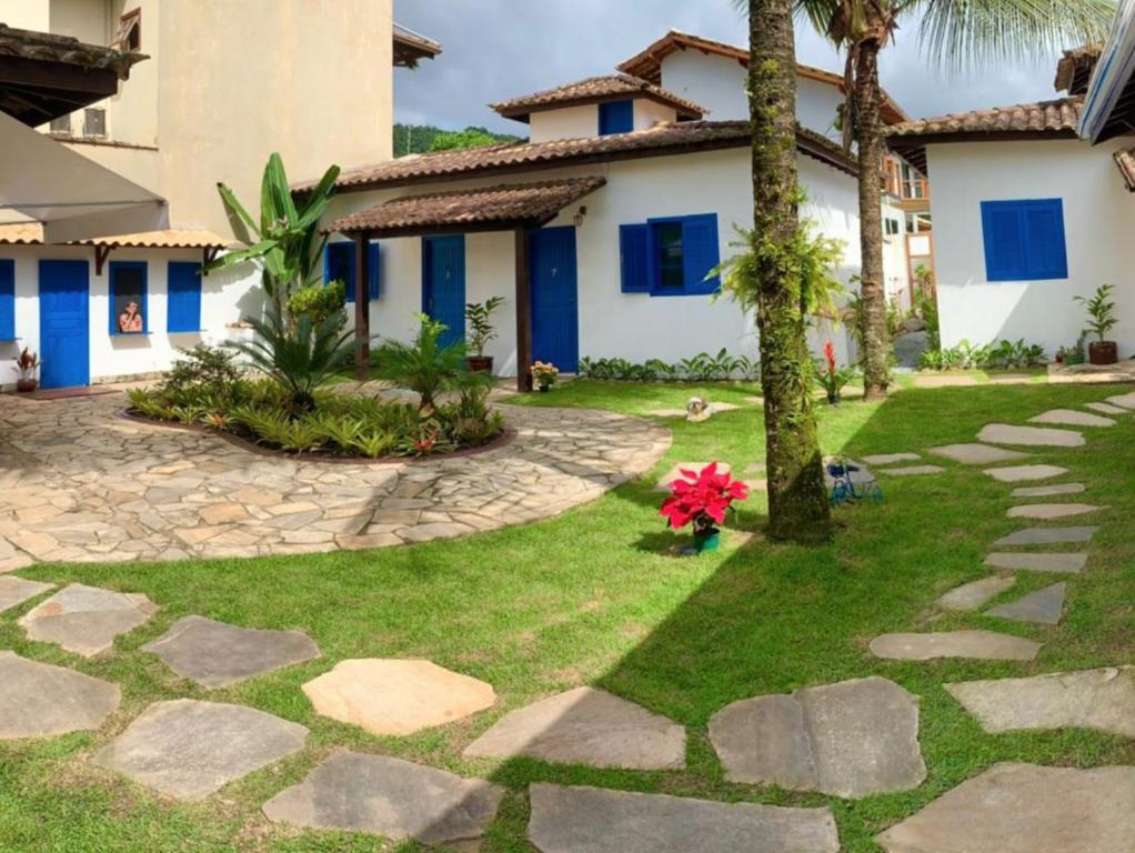 a garden in front of a house at Suítes Curta Paraty, Família e PETs in Paraty