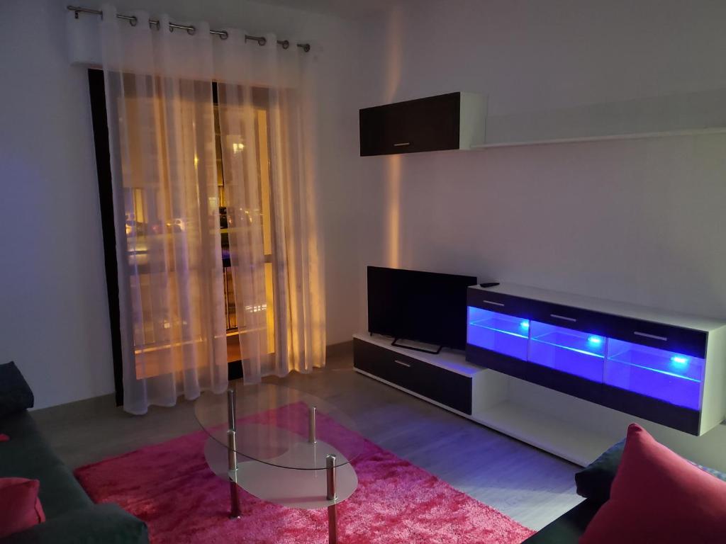 ein Wohnzimmer mit einem Flachbild-TV und einem Sofa in der Unterkunft Piso termal in Ourense