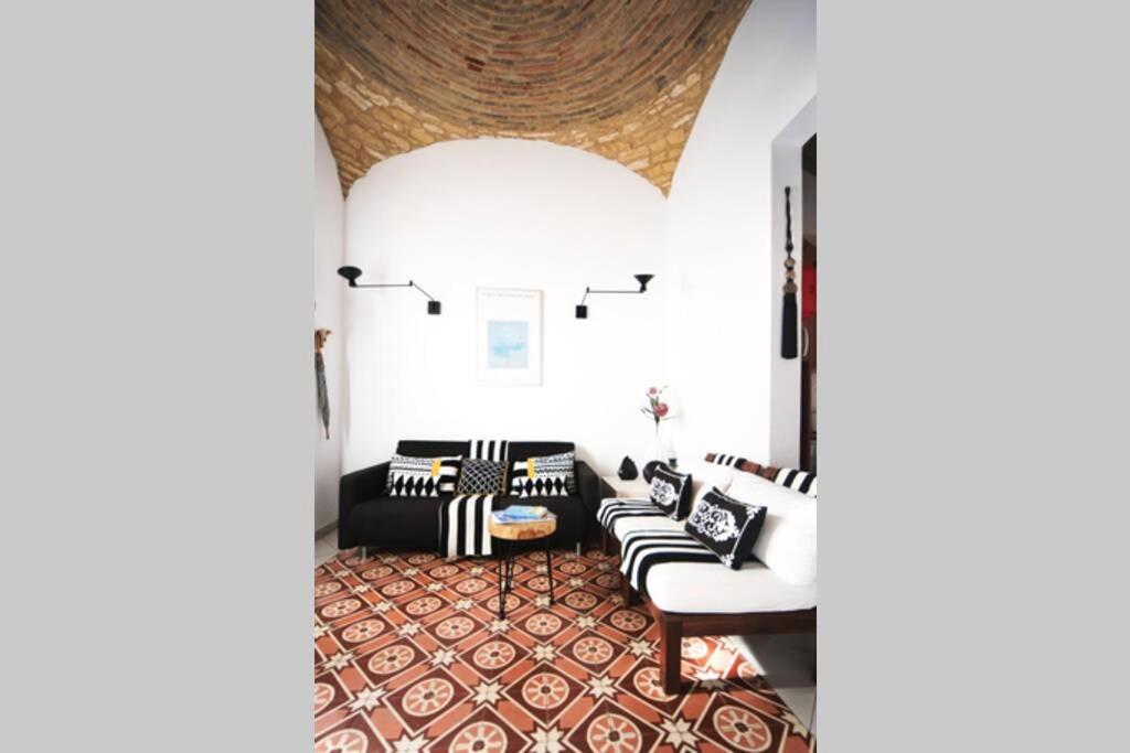 a living room with black and white couches and a rug at Casa Pombalinho, an old Fisherman Cottage in Fuzeta