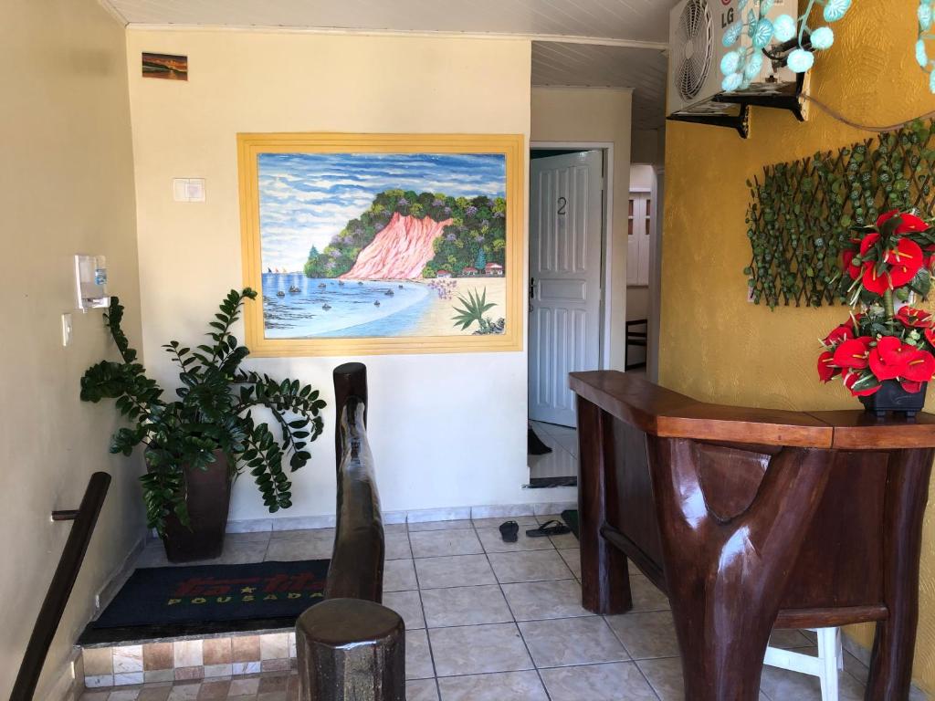 a living room with a painting on the wall at Pousada Tia Tita in Morro de São Paulo
