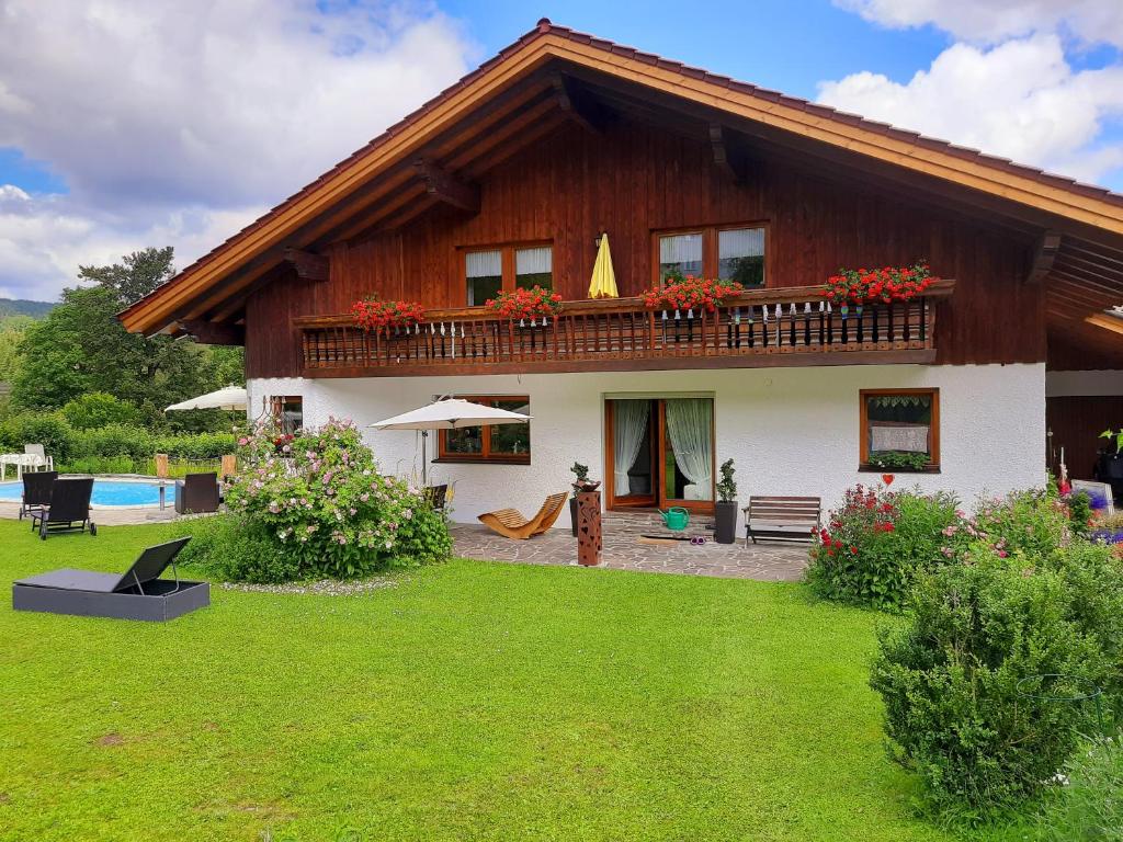 a house with a balcony and a yard at Apartments Josef Seitz in Bayerisch Eisenstein