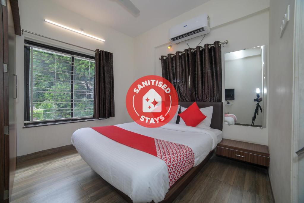 a bedroom with a bed with a red sign on it at Hotel Shelter in Nagpur