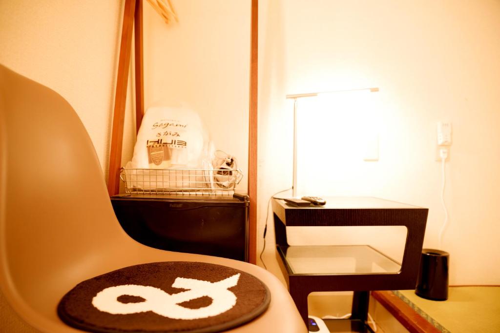 a chair with a sign on it next to a lamp at Hotel&Co. Sagami in Tokyo