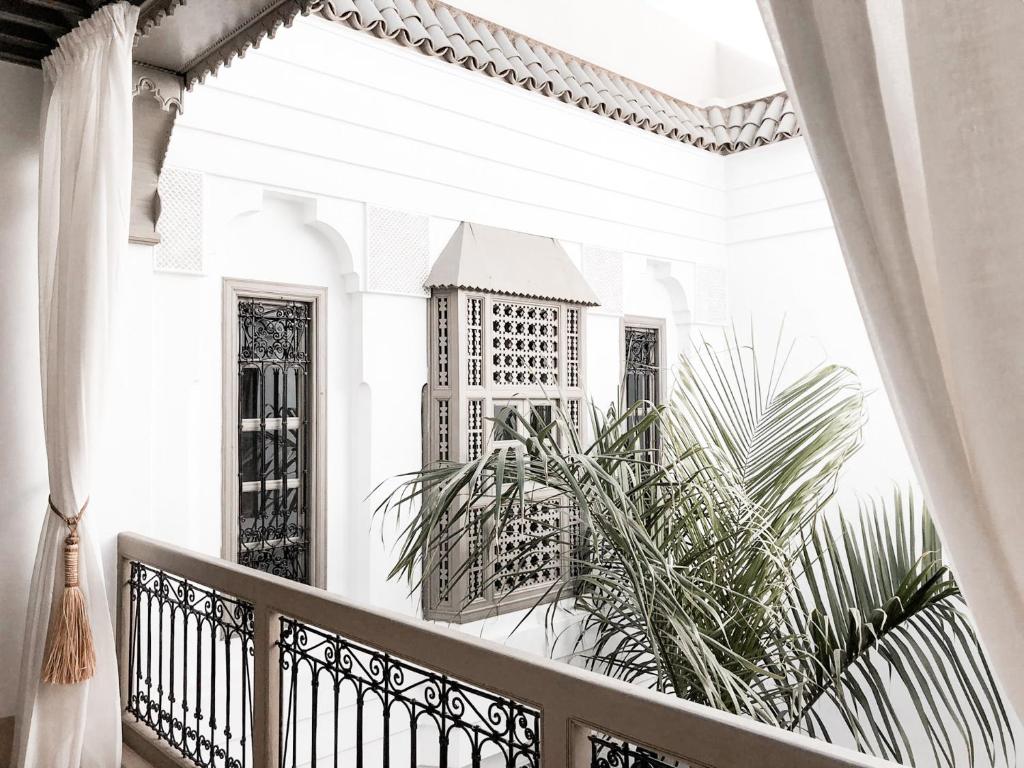 a balcony with a view of a building through a window at Riad Louhou in Marrakech