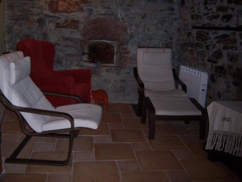 a living room with two chairs and a table at Casa Rafeleta Hotel in Plan