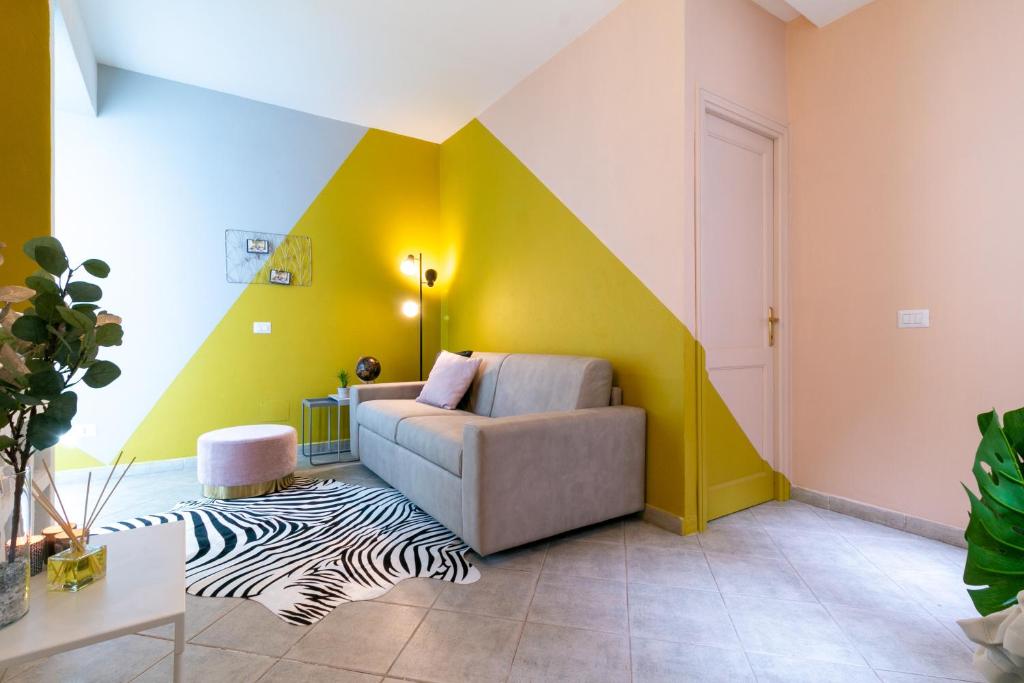 a living room with a couch and a yellow wall at BOUTIQUE APARTMENTS COLLECTION-GENIO RIBELLE in Sassari