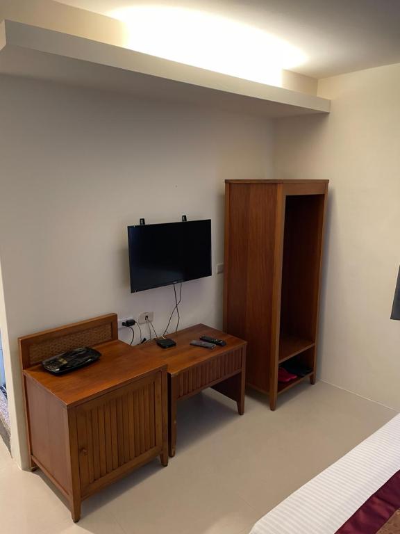 a living room with a tv and a wooden table at Hai Gang Yuan Homestay in Kenting