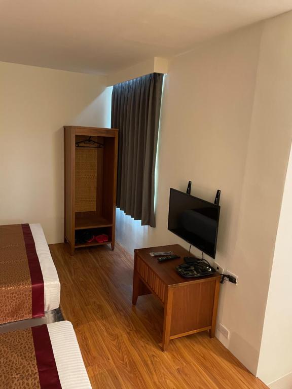 a room with a bed and a television on a table at Hai Gang Yuan Homestay in Kenting
