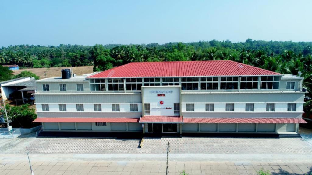 a large white building with a red roof at Fortune Village Hotel in Kundapur