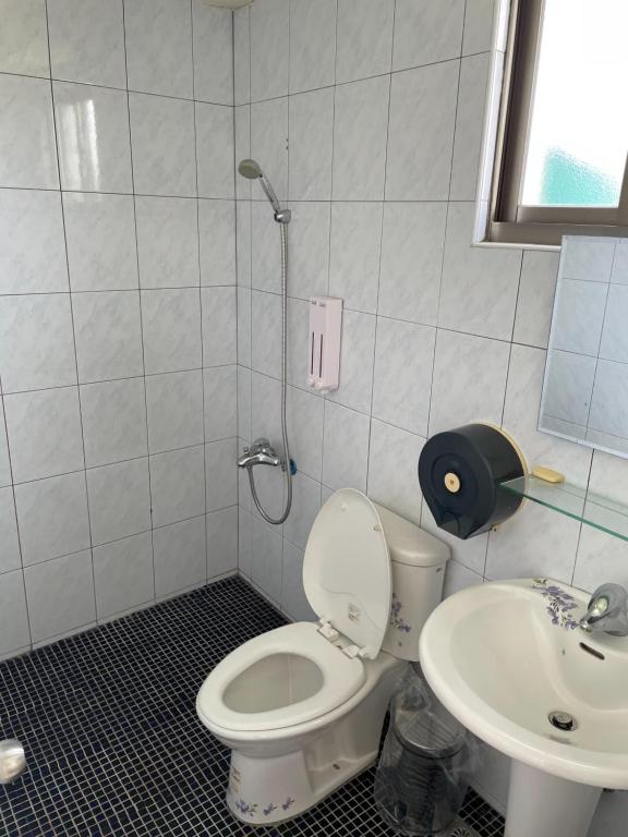a bathroom with a toilet and a sink at Hai Gang Yuan Homestay in Kenting