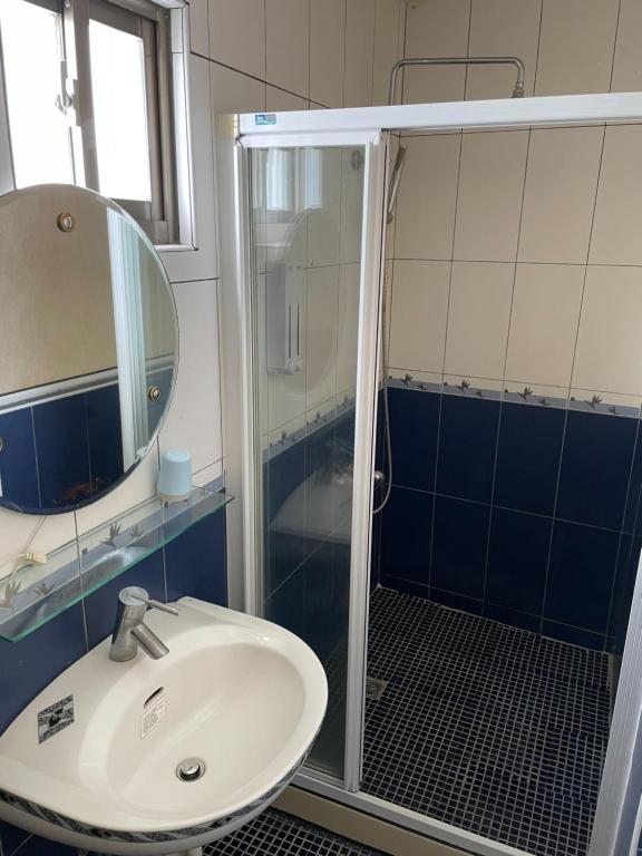 a bathroom with a sink and a shower with a mirror at Hai Gang Yuan Homestay in Kenting